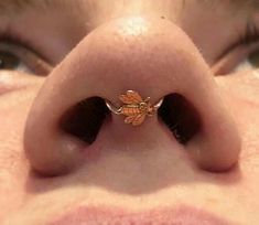 a close up of a person's nose with a tiny gold leaf on it