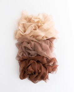 three different colored scrunffles sitting on top of each other in front of a white background