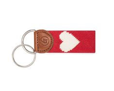 a red and white keychain with a brown leather tag on it's side