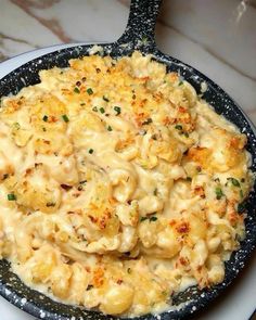 a skillet filled with macaroni and cheese on top of a white plate