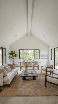 a living room with couches, chairs and a coffee table in the middle of it