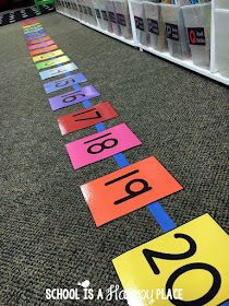 colorful signs on the floor in front of bookshelves with numbers painted on them