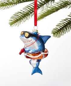 an ornament shaped like a shark hanging from a christmas tree