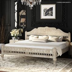 a bedroom with black walls, white furniture and a chandelier hanging from the ceiling