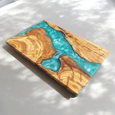 a piece of wood that is sitting on top of a white surface with blue water in it