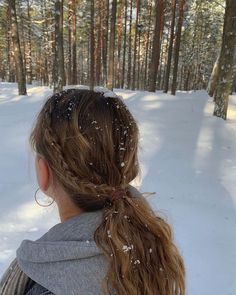 a woman with long hair standing in the snow