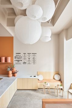 the interior of a restaurant with white paper lanterns hanging from the ceiling and wooden benches