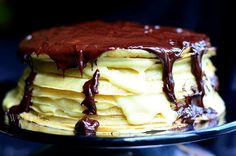 a stack of pancakes covered in chocolate sauce and drizzled with icing