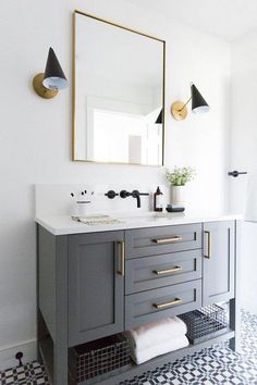 a bathroom with a sink, mirror and two lights on the wall above it's counter