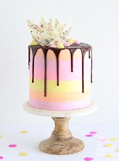 a colorful cake with chocolate drizzle and sprinkles on the top