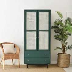 a green cabinet next to a wicker chair and potted plant