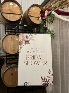 a sign that is sitting in front of some wine barrels with flowers on it and the words bridal shower