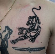 a man with a tattoo on his chest has a lion and knife in front of him