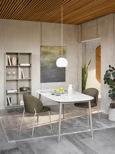 a white table and chairs in a room with wooden ceiling tiles on the floor, potted plant next to it