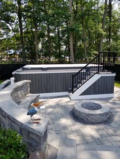 an outdoor patio with stone steps and fire pit in the center, surrounded by trees