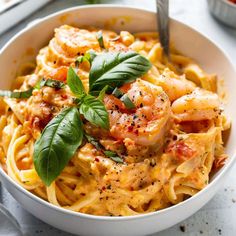 a white bowl filled with pasta and shrimp