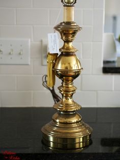 a golden candle holder with a price tag on it sitting on a black counter top