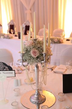 an image of a table setting with candles and flowers in the centerpieces on it