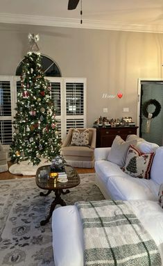 a living room filled with furniture and a christmas tree in the middle of the room