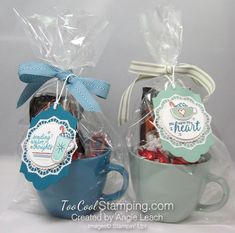 two mugs filled with candy and candies wrapped in cellophane to give as gifts