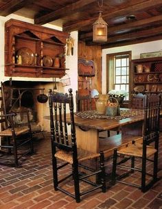 an old fashioned kitchen with brick flooring and wooden furniture in the dining room area