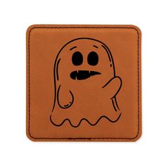 a brown leather coaster with a ghost drawn on it