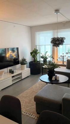 a living room filled with furniture and a flat screen tv sitting on top of a wall