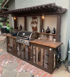 an outdoor bbq grill with lots of bottles on the top and shelves above it