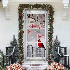 a decorated front door with christmas wreaths and decorations on the windowsill, in front of a white brick building