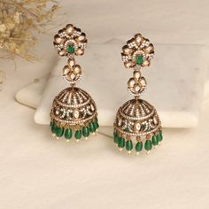 Description The Esther CZ Jhumka Earrings combine the classic and contemporary aesthetics seamlessly. They feature a distinctive design that draws inspiration from the Victorian era, embellished with sparkling CZ stones to enhance their allure. For an optimal effect, wear these exquisite earrings with your preferred Tarinika Jewelry pieces. Details & Specifications: Materials used: CZ Stone with Antique Gold Plating Weight - Earrings 31.35 gm Length - Earrings 7.5 cm Make it custom Want to make Fusion Style Tilla Earrings For Eid, Elegant Tilla Earrings For Eid, Hand Set Jhumkas For Diwali Reception, Festive Elegant Chandbali Jhumkas, Festive Chandbali Jhumkas, Festive Chandbali Jhumkas In Elegant Style, Traditional Bridal Earrings With Latkans And American Diamond, American Diamond Jhumkas For Celebration, Traditional Bridal Earrings With American Diamond And Latkans