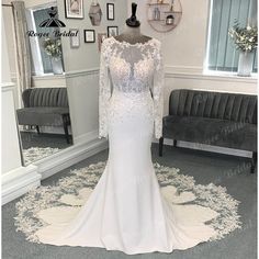 a white wedding dress on display in front of a mirror