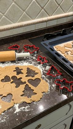 a kitchen counter with cookie cutters and dough on it, including heart shaped cookies