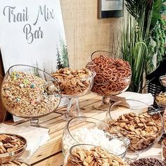 a table filled with lots of different types of food on top of glass bowls next to a sign