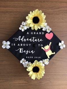 a graduation cap decorated with sunflowers and an image of winnie the pooh