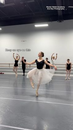 a group of ballerinas in a dance studio with their arms up and feet apart