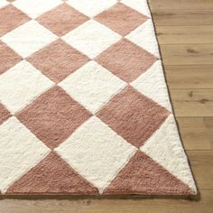 a pink and white rug on top of a wooden floor