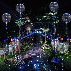 an outdoor wedding venue decorated with lights and balloons