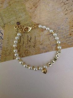 a bracelet with two charms on it sitting on top of a piece of paper