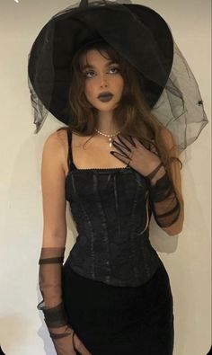 a woman wearing a black corset and hat