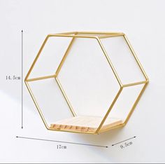 a gold hexagonal shelf is shown on the wall