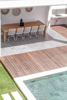 an aerial view of a table and chairs on a deck next to a swimming pool