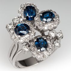 This impressive cluster style ring is accented with four (4), prong set, oval mixed cut natural sapphires, seven (7), prong set, round brilliant cut diamonds and forty-eight (48), prong set, round single cut diamonds. The ring measures 23.2mm at the top, rises 11.5mm above the finger, tapering to 3.9mm wide and 1.0mm thick at the base of the shank. This ring is currently a size 8.25. Luxury Sapphire Cluster Ring With Center Stone, Formal Sapphire Cluster Ring, Formal Cluster Sapphire Ring, Luxury Sapphire Cluster Ring, Elegant Multi-stone Sapphire Cluster Ring, Luxury Gia Certified Cluster Sapphire Ring, Elegant Sapphire Multi-stone Cluster Ring, Luxury Multi-stone Cluster Sapphire Ring, Luxury Blue Multi-stone Cluster Ring