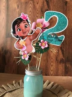 a mason jar filled with flowers and a paper cut out of the character moana