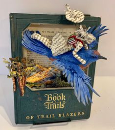 a book that has some kind of blue bird on it's back and is made out of books