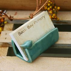 a small book sitting on top of a wooden bench next to some branches and berries