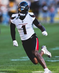 a football player is running on the field with his foot in the air while wearing a helmet