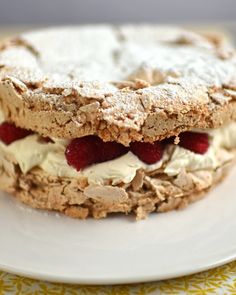 a close up of a sandwich on a plate with strawberries and powdered sugar