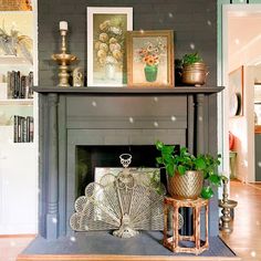 a living room filled with furniture and a fire place covered in pictures on top of a mantle