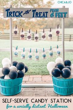 two buckets filled with black and white balloons next to a sign that says trick or treat