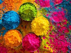 three bowls filled with different colored powders on top of a table next to each other